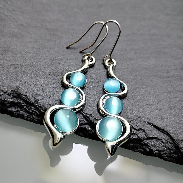 Boucles d'oreilles pendantes en pierre de lune bleue Boucles d'oreilles en zircon cubique bleu pour femme Boucles d'oreilles ondulées courbes créativ